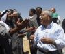 Palestinian Prime Minister Salam Fayyad, right, speaks with a cave dweller in Mufaqara