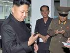Kritischer Blick - Nordkoreas Staatschef Kim Jong Un (M.) betrachtet eines der neuen Smartphones. Foto: AFP