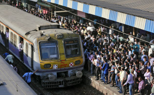 駅で電車を待つムンバイの通勤者ら。混雑もインドの鉄道の深刻な課題だ＝ＡＰ