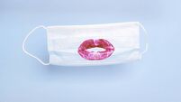 Medical mask with print of female lipstick kiss lips on blue background. Prevention and protection of the population during an e