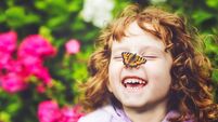 Laughing girl with a butterfly on his nose