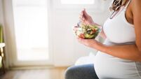Beautiful pregnant woman eating healthy food and salads
