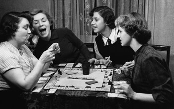 Young actress Veronica Hurst (second from left) plays a board game with family members. 